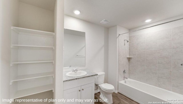 full bathroom with toilet, tiled shower / bath, hardwood / wood-style floors, and vanity