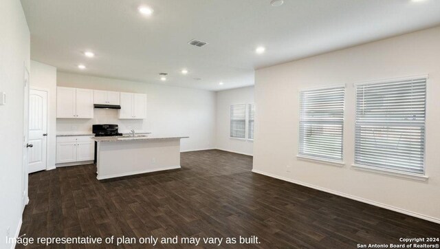 kitchen with a center island with sink, sink, white cabinetry, black range oven, and dark wood-type flooring