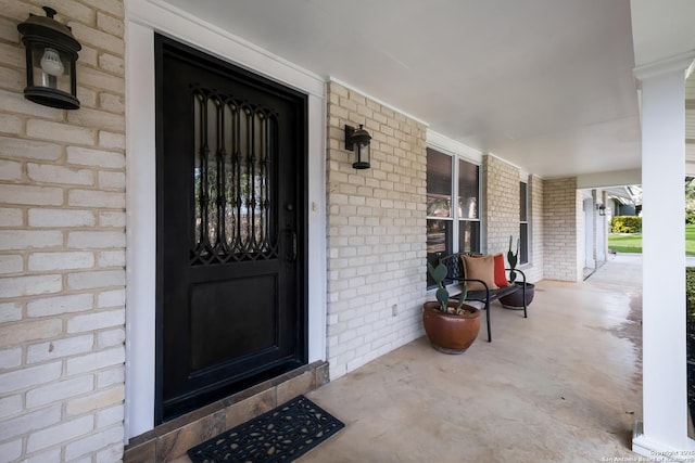 view of exterior entry featuring covered porch