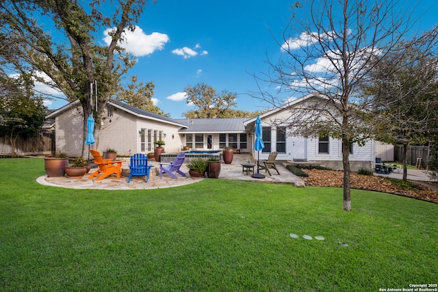 back of house with a yard, a fire pit, and a patio