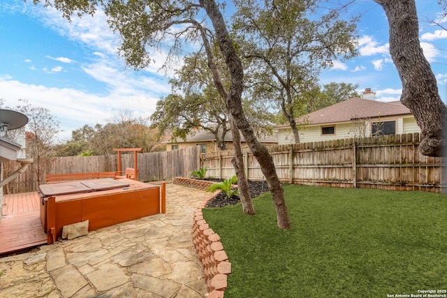 view of yard featuring a deck, a patio area, and a hot tub