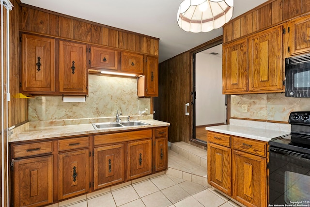 kitchen featuring black appliances, light tile patterned floors, decorative backsplash, and sink