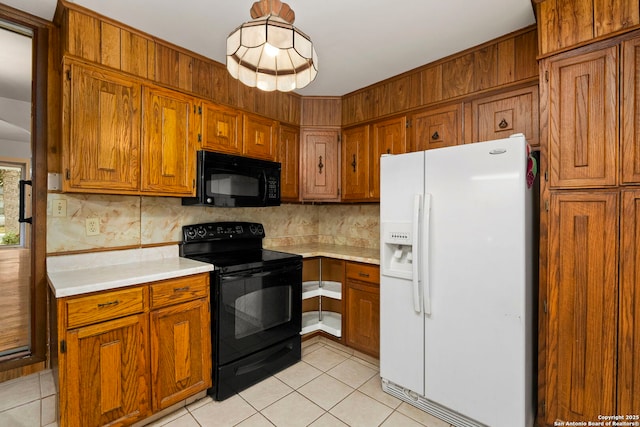 kitchen featuring black appliances, light tile patterned floors, and hanging light fixtures