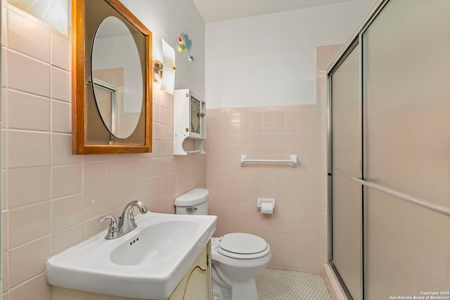 bathroom featuring a shower with shower door, tile walls, tile patterned floors, and toilet