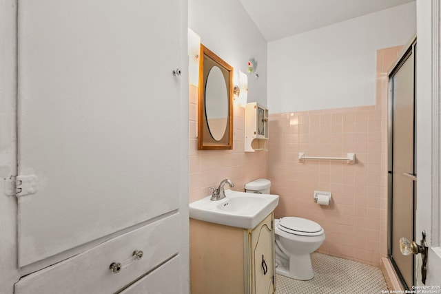 bathroom featuring a shower with door, tile walls, tile patterned floors, and vanity