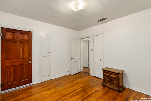 unfurnished bedroom with a closet and hardwood / wood-style flooring