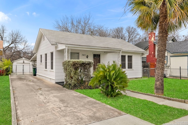 bungalow-style home with a garage, a front yard, and an outdoor structure