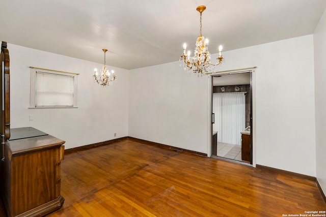 unfurnished dining area featuring dark hardwood / wood-style flooring and an inviting chandelier