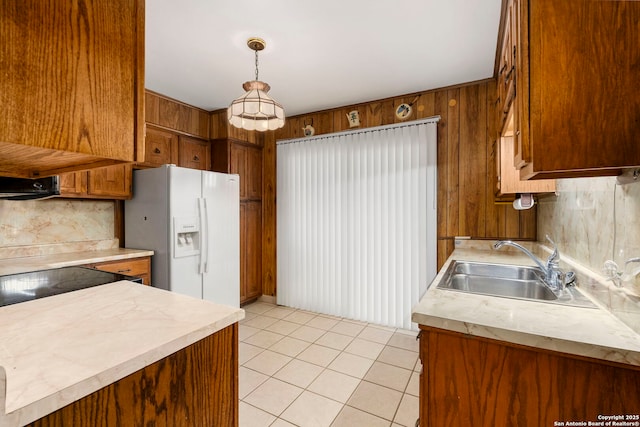 kitchen with white refrigerator with ice dispenser, decorative backsplash, sink, hanging light fixtures, and light tile patterned floors