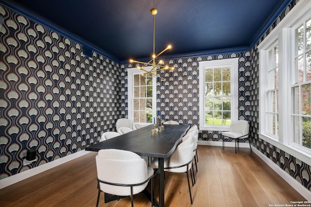 dining area featuring a notable chandelier, crown molding, and light hardwood / wood-style flooring