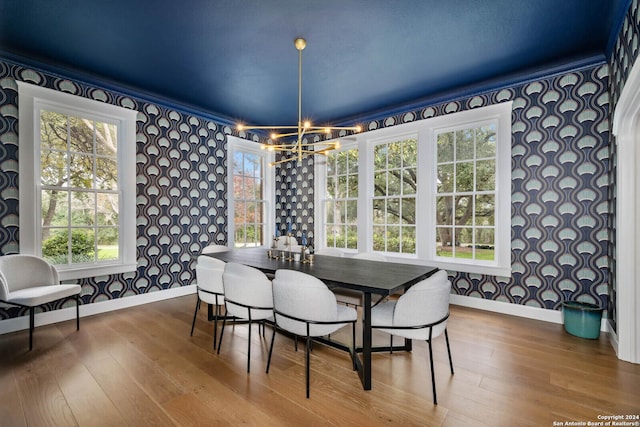 dining area with wood-type flooring and a notable chandelier