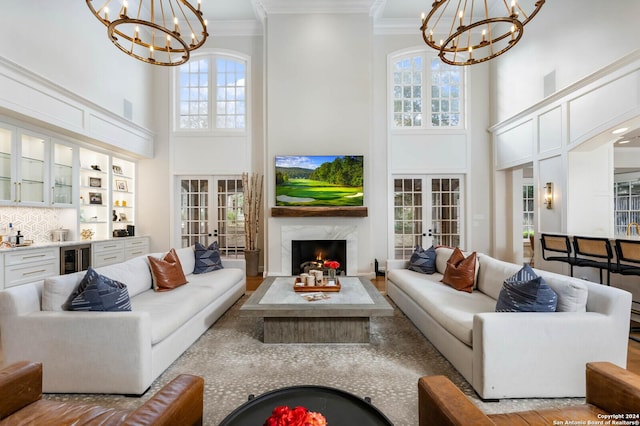 living room with an inviting chandelier, a fireplace, and french doors