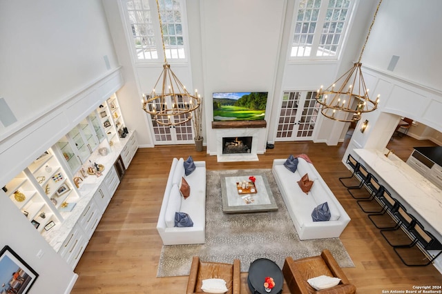 living room with french doors, wood-type flooring, and a chandelier