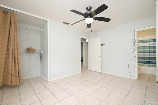 unfurnished bedroom with ceiling fan, ensuite bath, a closet, and light tile patterned flooring