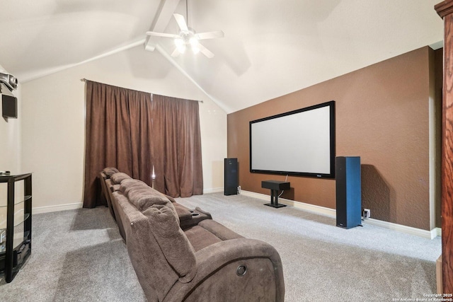 carpeted home theater with ceiling fan and lofted ceiling with beams