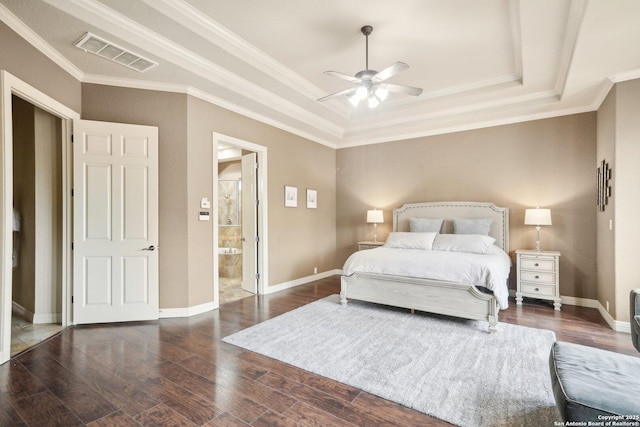 bedroom featuring ensuite bath, dark hardwood / wood-style floors, ornamental molding, ceiling fan, and a tray ceiling