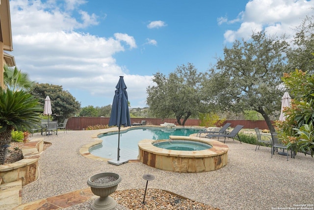 view of pool featuring a patio area and an in ground hot tub