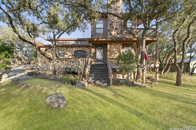 back of property featuring a wooden deck and a yard