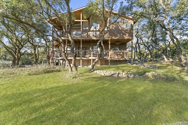 rear view of property with a wooden deck and a yard