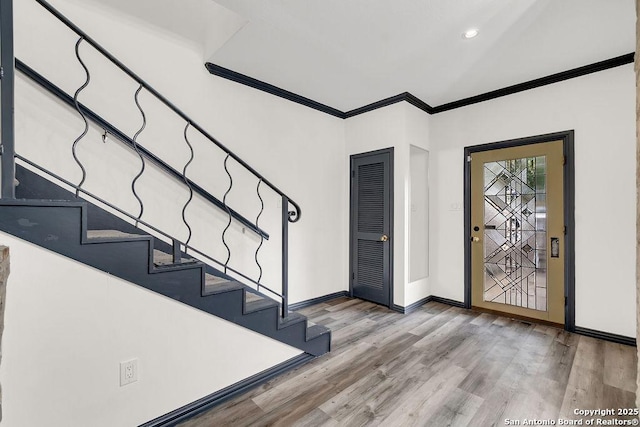 entrance foyer with crown molding and light hardwood / wood-style flooring