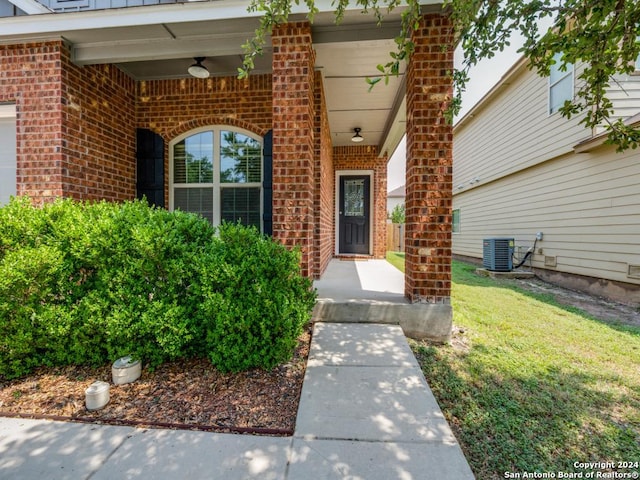 property entrance with central AC unit and a lawn