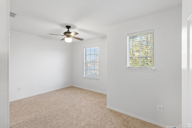 empty room with ceiling fan and light carpet