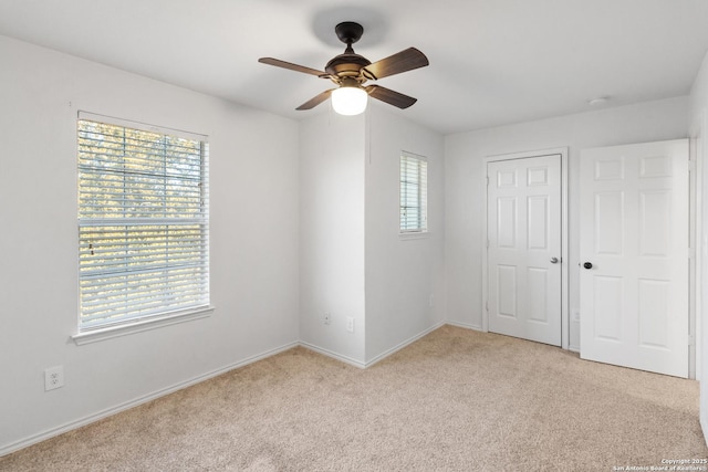 unfurnished bedroom featuring ceiling fan, a closet, and light carpet