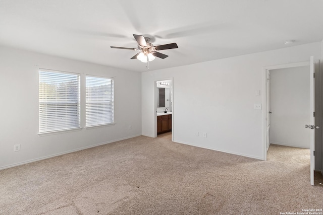 unfurnished bedroom featuring ceiling fan, connected bathroom, light colored carpet, and sink