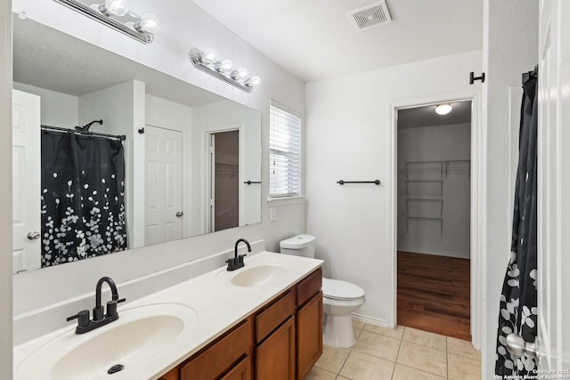 bathroom featuring toilet, tile patterned flooring, and vanity