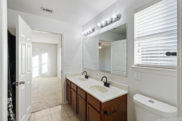 bathroom featuring ceiling fan, vanity, tile patterned floors, and toilet