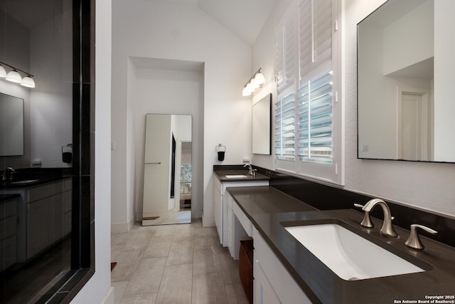 bathroom featuring tile patterned floors, vanity, and vaulted ceiling