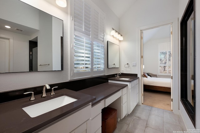 bathroom with lofted ceiling, vanity, and tile patterned flooring