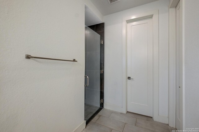 bathroom featuring tile patterned flooring and a shower with door