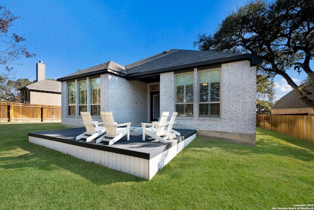 rear view of house featuring a yard