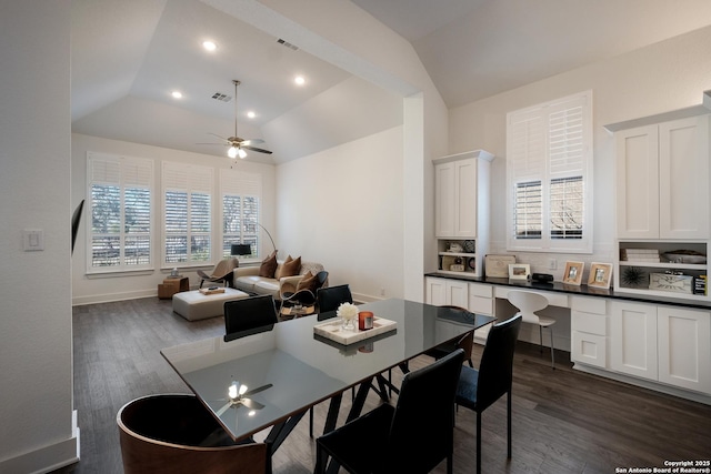 dining area featuring ceiling fan, vaulted ceiling, and dark hardwood / wood-style flooring