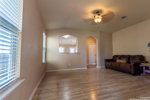 living room with ceiling fan, wood-type flooring, and vaulted ceiling