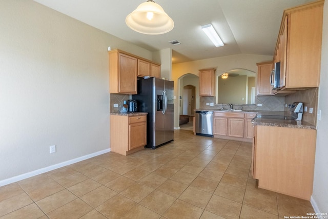 kitchen with light tile patterned floors, appliances with stainless steel finishes, tasteful backsplash, lofted ceiling, and sink