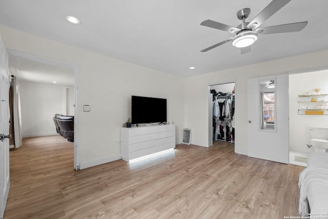 bedroom featuring ensuite bathroom, ceiling fan, light wood-type flooring, a walk in closet, and a closet