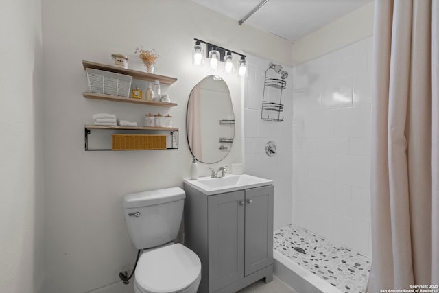 bathroom featuring toilet, vanity, and a tile shower