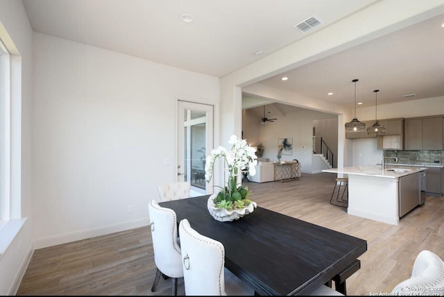 dining room featuring light hardwood / wood-style floors, sink, and ceiling fan