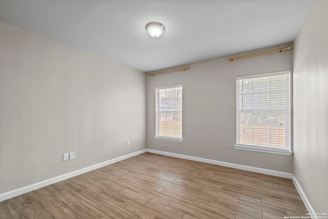 unfurnished room featuring light wood-type flooring and plenty of natural light