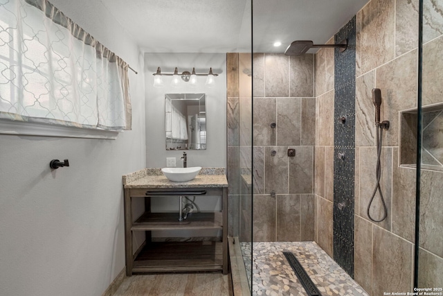 bathroom featuring a tile shower and vanity