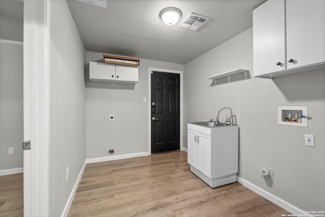 clothes washing area with cabinets, electric dryer hookup, sink, hookup for a washing machine, and light wood-type flooring