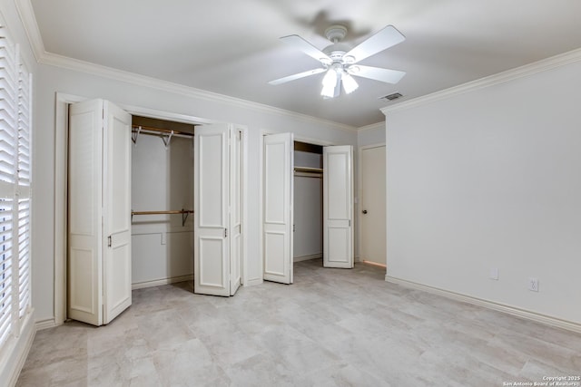 unfurnished bedroom featuring ceiling fan, ornamental molding, and multiple closets