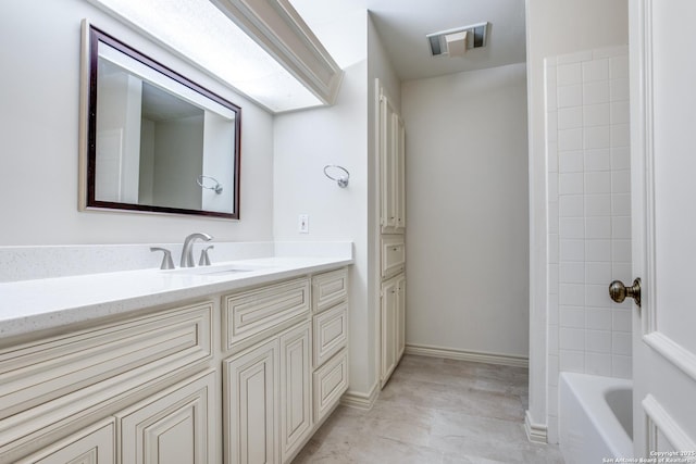 bathroom with tiled shower / bath and vanity