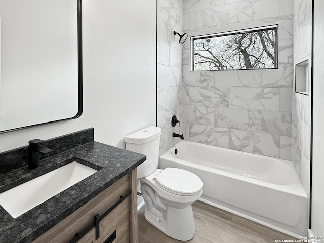 full bathroom with toilet, vanity, tiled shower / bath combo, and hardwood / wood-style flooring