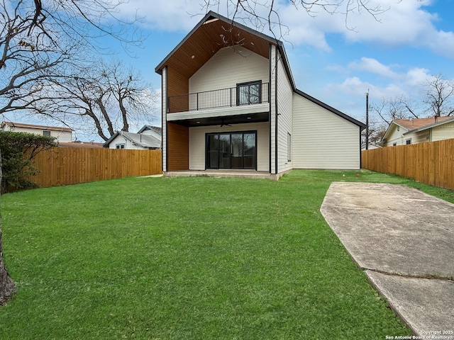 rear view of house featuring a balcony, a patio area, and a yard