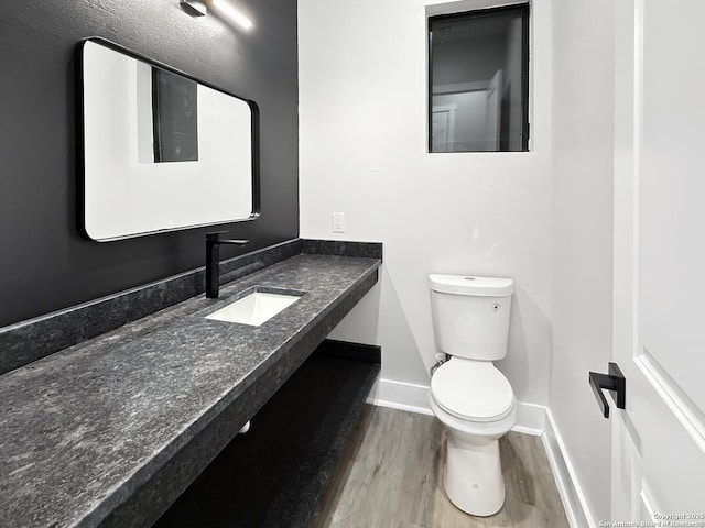 bathroom featuring toilet, hardwood / wood-style floors, and vanity