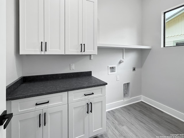 laundry room featuring electric dryer hookup, light wood-type flooring, washer hookup, cabinets, and gas dryer hookup