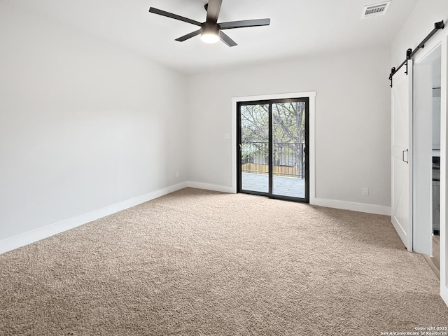 unfurnished bedroom featuring ceiling fan, a barn door, carpet floors, and access to outside